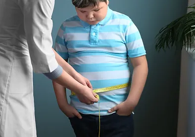 A person measuring the waist of a child