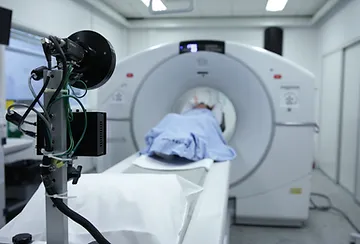 A person is lying on the bed in front of an mri machine.