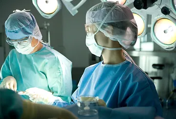 A surgeon and another person in the operating room.