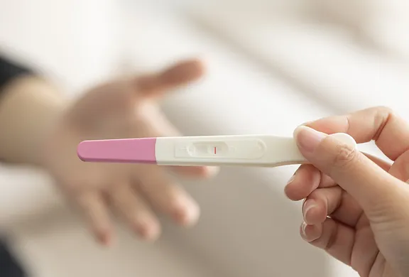 A person holding a baby thermometer in their hand.